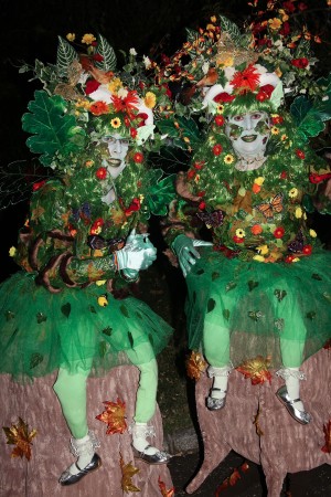 Two forest nymphs with light up wings sitting on stumps.