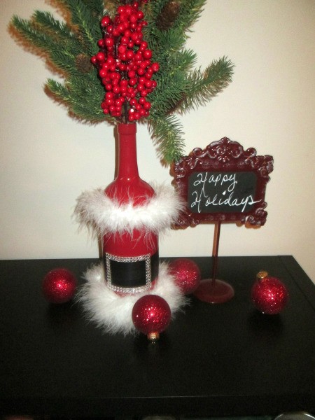Santa Vase And Lamp - greenery added to bottle to use as a vase, displayed with a sign saying Happy Holidays and some Christmas ornaments