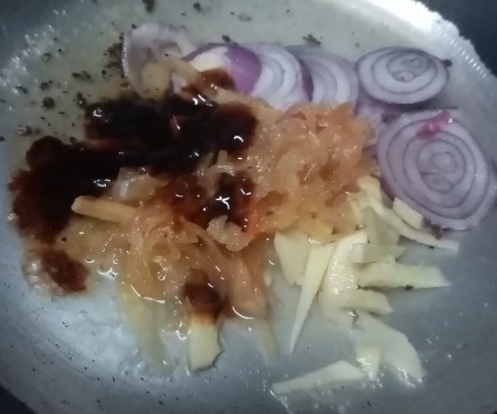 adding oyster sauce to cut veggies