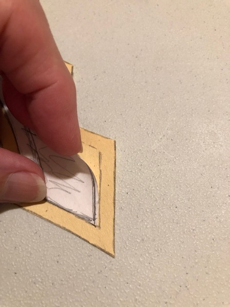 English Paper Pieced Flower Pillow - closeup of template and underlying newsprint