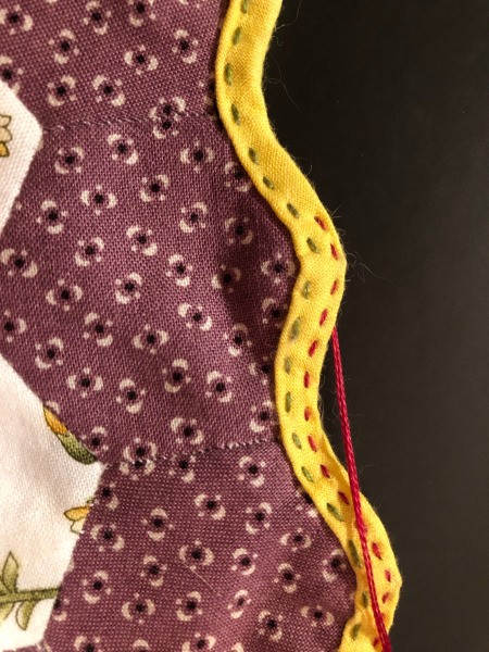 English Paper Pieced Flower Pillow - closeup of stitching the bias tape to the edge of the flower