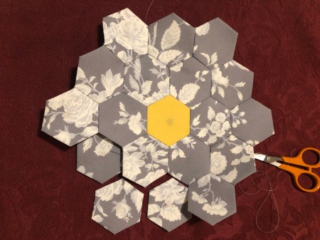 English Paper Pieced Flower Pillow - keep working around the piece stitching hexagons in place