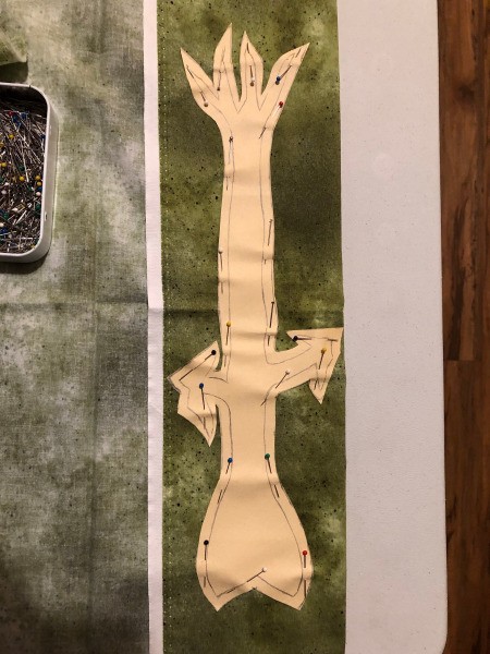 English Paper Pieced Flower Pillow - green stem fabric folded and template pinned in place to cut 2 of the 4 pieces needed