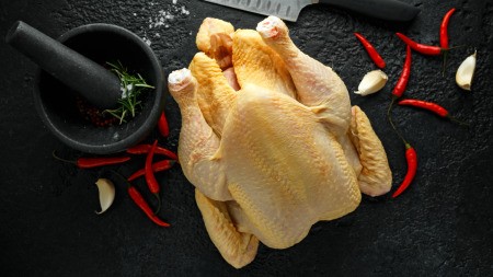 A whole chicken being prepared for cooking.