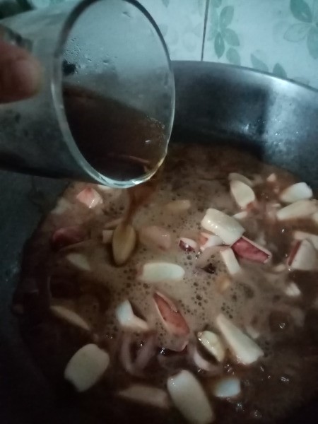 addingsoda & soy sauce to onions in pan