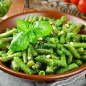 A green bean side dish served with pine nuts.