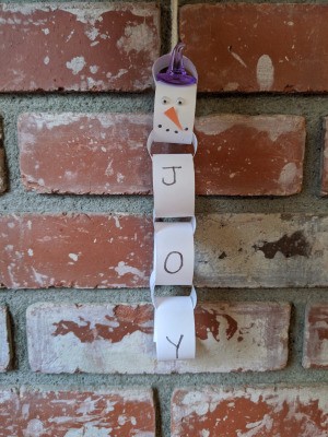 Snowman/Joy Paper Chain Ornament - hanging on the brick fireplace