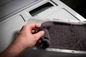 Dryer lint being removed from a dryer.