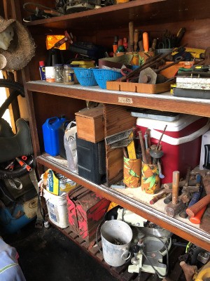 Tools organized on a shelf with recycled cans.