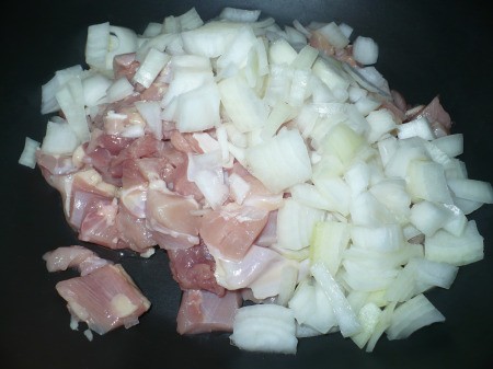 adding onion to chicken in wok