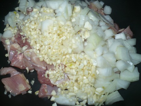 adding garlic & onion to chicken meat