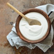 Homemade yogurt in a bowl with a wooden spoon.