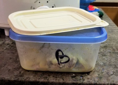 A container with a blue lid that is marked with a "B".