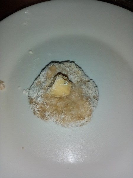 adding cheese to piece of dough