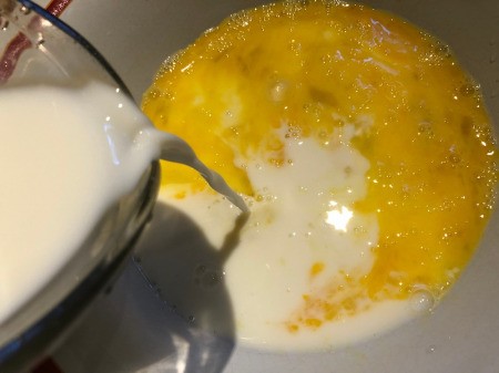 pouring milk in beaten eggs
