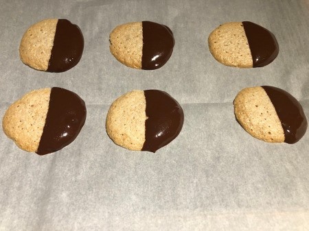 Chocolate Dipped Peanut Butter Meringues on parchment paper