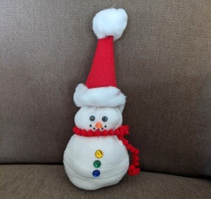 No-Sew Christmas Sock Snowman - finished snowman on a beige couch