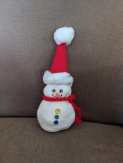 No-Sew Christmas Sock Snowman - finished snowman on a beige couch