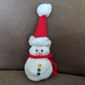 No-Sew Christmas Sock Snowman - finished snowman on a beige couch