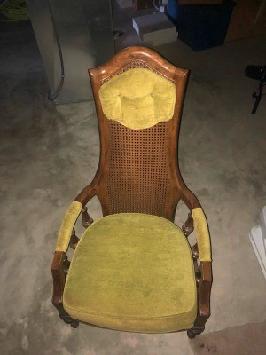 Value of a Jack Brandt Chair - wooden cane back chair with upholstered headrest, part of the arms, and a cushion
