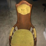 Value of a Jack Brandt Chair - wooden cane back chair with upholstered headrest, part of the arms, and a cushion