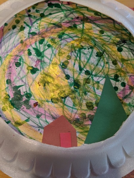 Paper Plate Framed Christmas Decoration - paper plate frame around the artwork with the tree and house cutouts added