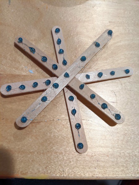 Making Popsicle Stick Snowflake Ornaments - blue dots on all sticks