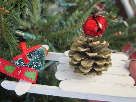 Popsicle Stick Sled - white sled with wreath and pinecone decorations