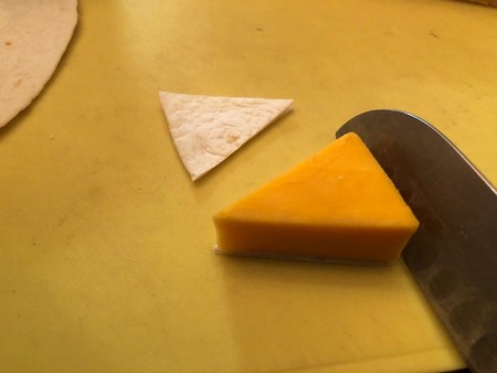 slicing cheese wedge through the middle