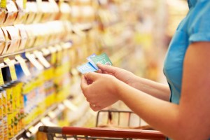 A woman using coupons when grocery shopping.