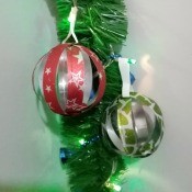 Recycled Plastic Bottle Christmas Balls - finished balls hanging on a lighted piece of garland