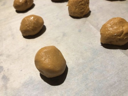 Peanut Butter balls on parchment paper to freeze