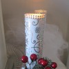 An inexpensive candle that has been decorated with wrapping paper and gems.