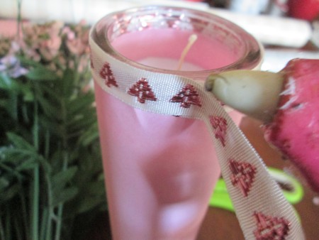 Decorating an inexpensive candle with ribbon.