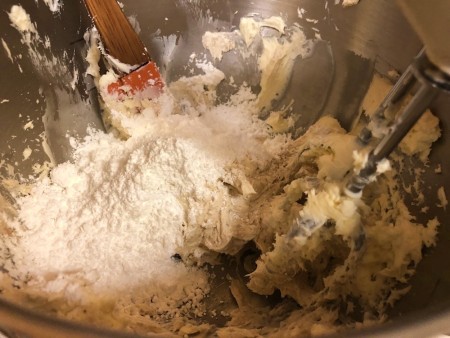 adding powdered sugar to frosting
