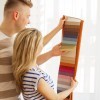 Man and a woman looking at curtain fabric swatches.