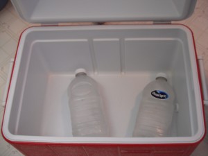 A cooler with ice in recycled bottles.