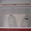 A cooler with ice in recycled bottles.