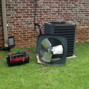 air conditioner unit outside home with tool kit next to it