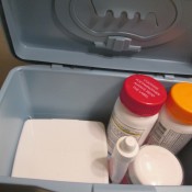 Medicine and supplies inside a baby wipe container.