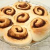 A glass pie plate filled with cinnamon rolls.