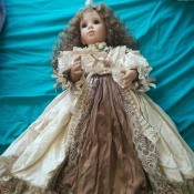 Value of an Ashton Drake Porcelain Doll - doll wearing a long dress with taupe lace