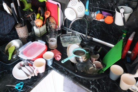 A messy and cluttered kitchen counter.