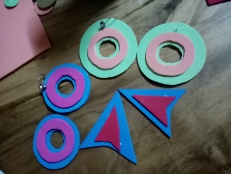 Colorful Retro Inspired Foam Earrings - three sets of earrings, the pink and blue, a darker blue with a purple smaller ring, and triangular ones with curved bottoms made in the dark blue with a  magenta topper