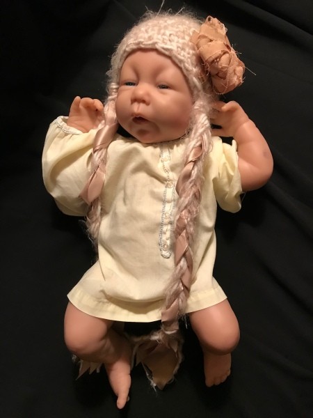 Value of an Ashton Drake Silicon Doll  - doll in yellow outfit wearing a hat with braids