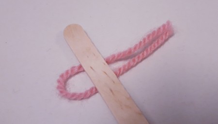 Wood and Yarn Centipede - yarn folded in half and placed under the stick with the ends to the right and loop to the left