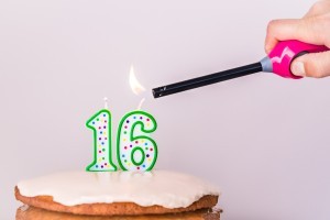 Lighting candles on a 16th birthday cake.
