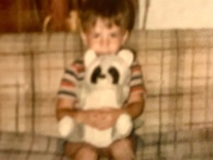 Identifying a Stuffed Raccoon - very fuzzy photo of a young boy holding a stuffed raccoon