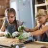 Two young girls working on a craft project with wood.