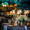 Wedding table with candles in tall glass cups.